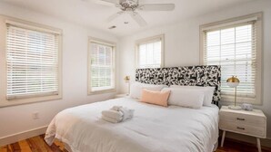 A bedroom with a bed, white walls, wooden flooring, and a ceiling fan. - 4BR Charleston Single! One Block to King St! (Charleston)