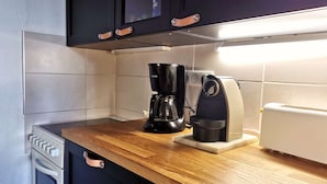 A compact kitchen with a coffee maker, toaster, and a small oven.