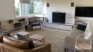 A living room with a fireplace, a sofa, a coffee table, and a television. - Bear Mountain House. (Philipstown)