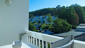 A balcony with a white table and chairs, overlooking a residential area with houses and trees. - Baltic Building, Apartment 12, Balcony, Elevator, Central Location (Sellin)