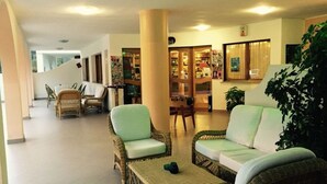 A spacious lobby with wicker furniture, a staircase, and a bar area. - Complesso Il Saraceno (Maracalagonis)