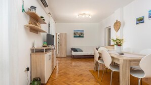 A compact living space with a kitchenette, dining area, and a sofa. - Cozy apartment in Njivice with WiFi (Njivice)