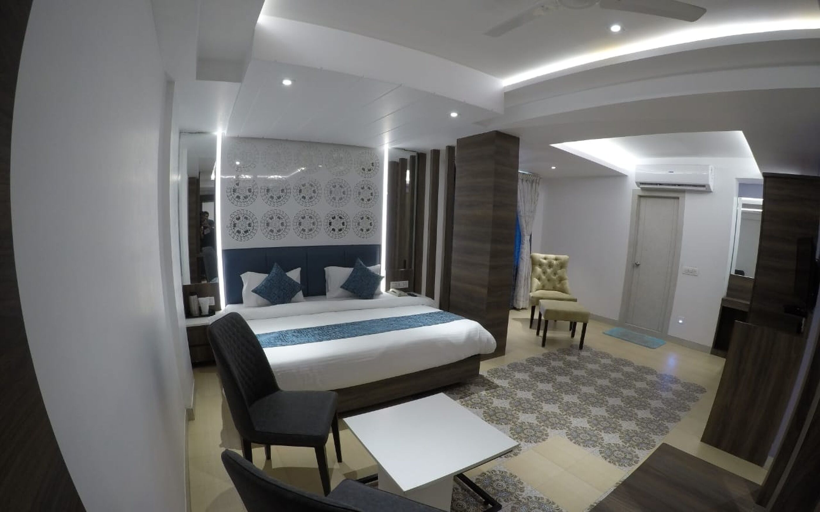 Een moderne hotelkamer met een groot bed, een bureau, een stoel en een kledingkast.