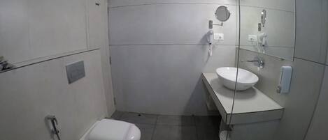 Un baño pequeño y moderno con inodoro, lavamanos y espejo.