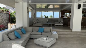 A modern living room with a sectional sofa, a coffee table, and a dining area with chairs.