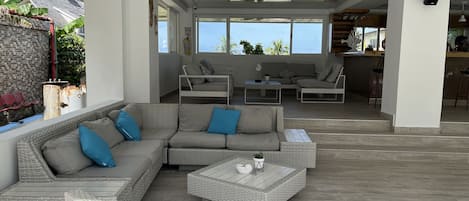 A modern living room with a sectional sofa, a coffee table, and a dining area with chairs.