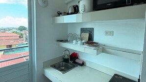 Een praktische keuken met een magnetron, waterkoker en een kleine koelkast.