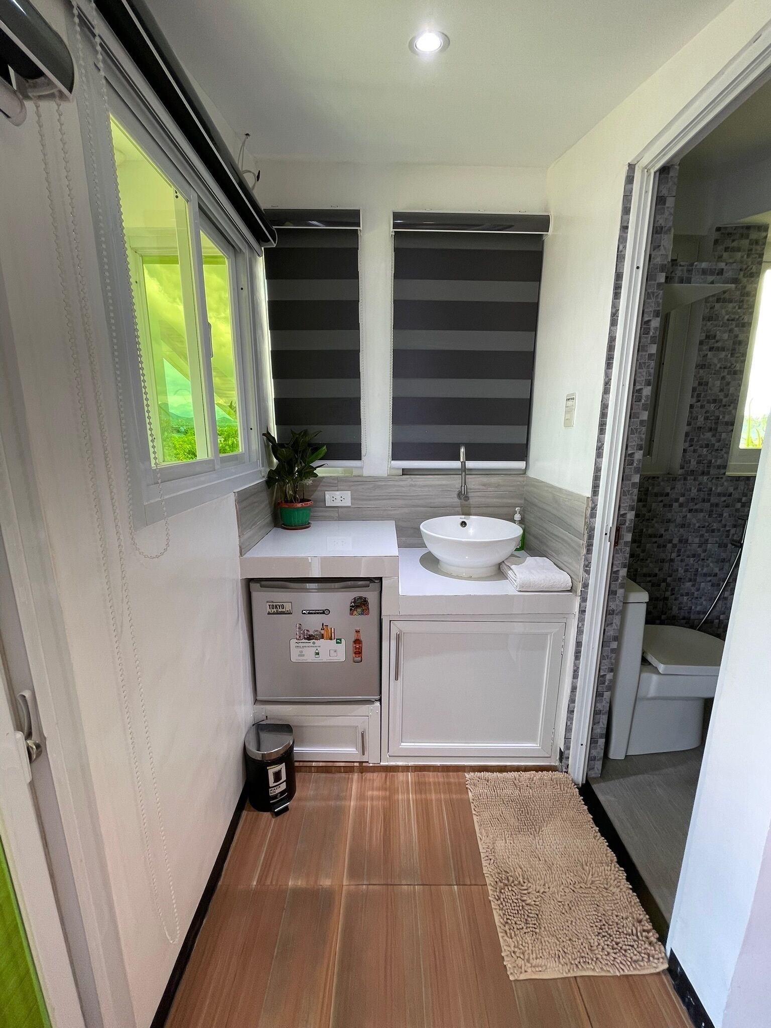 A compact bathroom with a sink, toilet, and shower.
