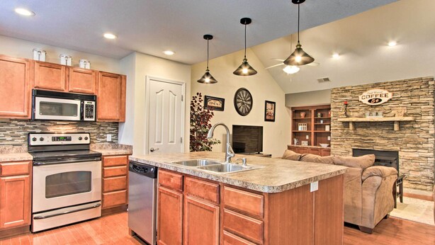 A modern kitchen with granite countertops, stainless steel appliances, and wooden cabinets.