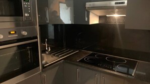 A modern kitchen with stainless steel appliances, including a microwave, oven, and stove. - Very nice apartment F3 comfortable. (Agadir)