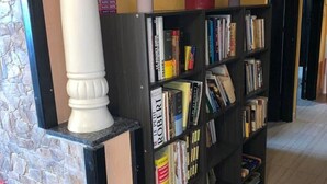 A library with bookshelves, a stone wall, and a white column. - Very nice apartment F3 comfortable. (Agadir)