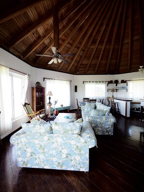 Relax in this spacious living area with a sofa set, dining table, and kitchen bar.