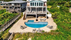 A large, two-story house with a swimming pool and outdoor seating area.