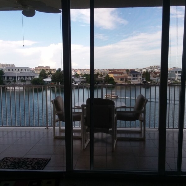 A balcony with a view of a river and buildings across it.