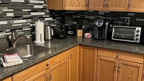 A kitchen with wooden cabinets, a granite countertop, a sink, a toaster, a blender, and a coffee maker. - Beautiful 2 bedroom walkout basement apartment close to U of G (Guelph)