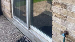A sliding glass door with a security keypad and a wall-mounted outdoor light fixture. - Beautiful 2 bedroom walkout basement apartment close to U of G (Guelph)