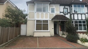 A two-story house with a bay window, a front door, and a small porch. - Right Stays (Guildford)