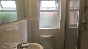 A bathroom with a sink, toilet, and a shower. - Right Stays (Guildford)