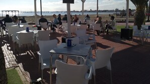 An outdoor dining area with tables and chairs, a covered seating area, and a view of the beach and water. - APARTMENT SEA MINOR 50MTS SPECIAL BEACH VACATION REST AND FUN (San Pedro del Pinatar)