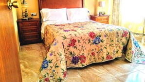 A bedroom with a wooden bed frame, floral bedspread, a nightstand with a lamp, and a dresser. - APARTMENT SEA MINOR 50MTS SPECIAL BEACH VACATION REST AND FUN (San Pedro del Pinatar)