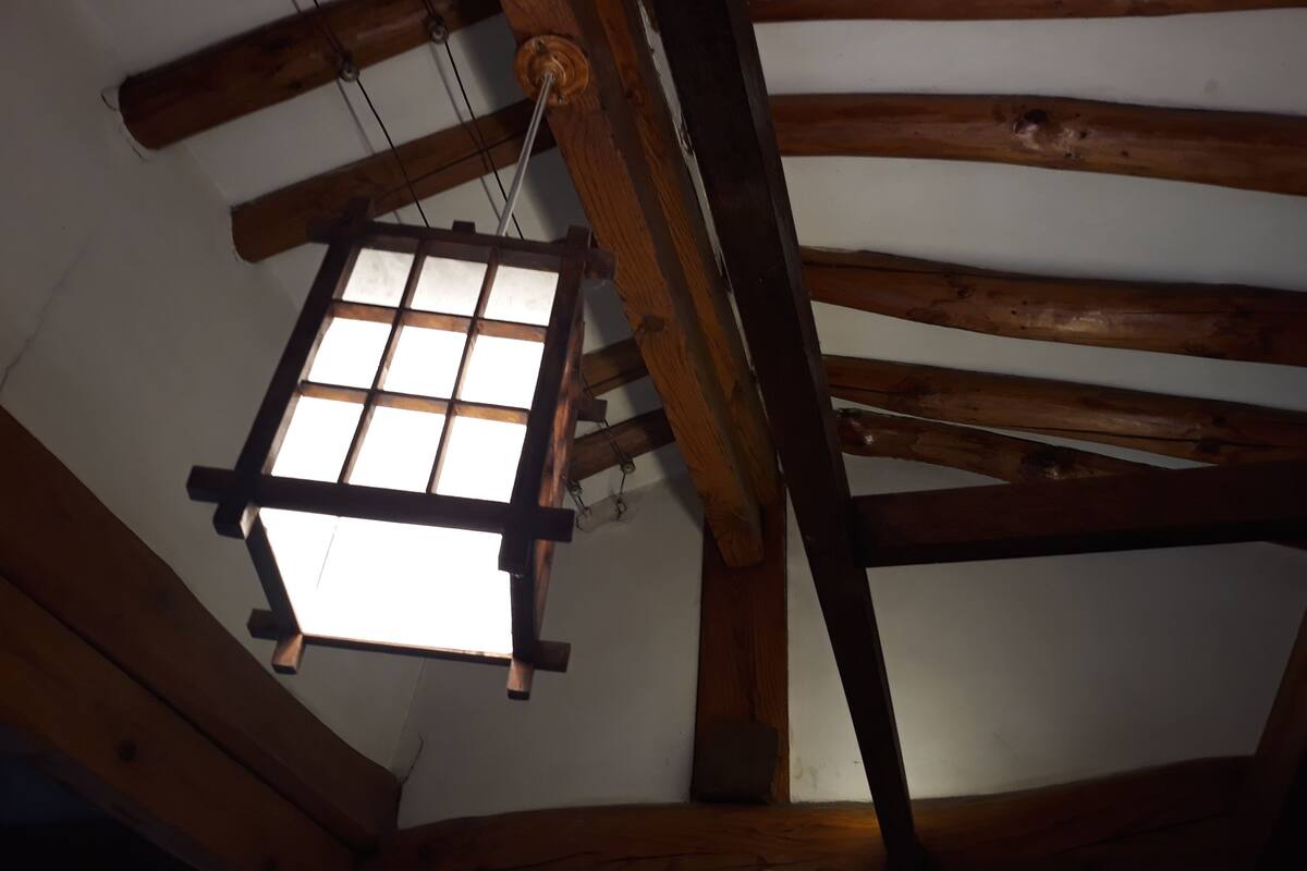 A wooden ceiling with exposed beams and a window.