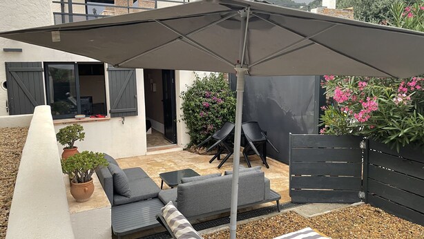 A patio with outdoor furniture, a pergola, and a view of the backyard. - Comfortable studio in the Gulf of St Tropez (Cavalaire-sur-Mer)