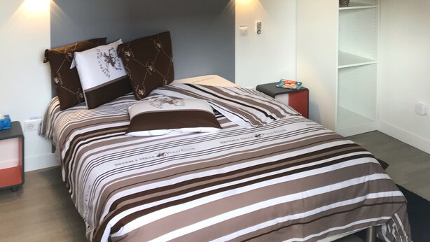 A modern bedroom with a bed, bedside tables, and a wall-mounted shelf. - independent house (Chartres)