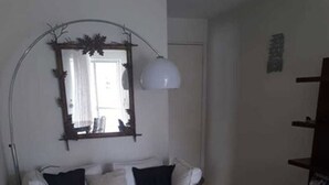 A living room with a sofa, a coffee table, and a lamp. - Apartamento Itaim Bibi (São Paulo)