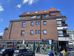 A multi-story brick building with a storefront on the ground floor. - Penthouse maisonette Lagmöwe (Westerland)