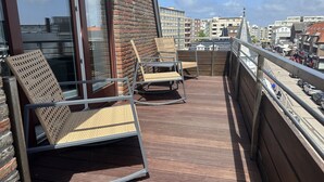 A balcony with wicker chairs and a view of the cityscape. - Penthouse maisonette Lagmöwe (Westerland)
