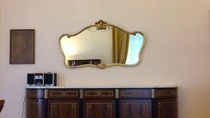 Un aparador de madera con un espejo dorado encima.