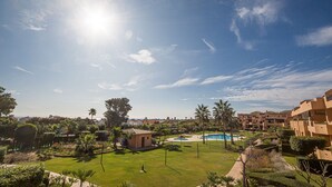 Un resort con piscina, palme e un cielo azzurro limpido.