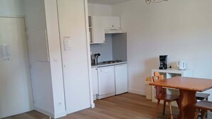 A compact living space with a kitchenette, a dining area, and a small seating area. - 2-Room Apartment for 4 in Vignec (Vignec)