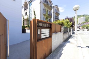 Experience the sleek entrance of Brunet-9, featuring a secure keypad and beautifully maintained garden.