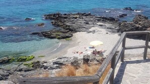 A coastal walkway with a wooden railing, leading to a rocky beach area with clear blue water and a view of the ocean. - Spacious and bright penthouse with panorama seaview (Nerja)