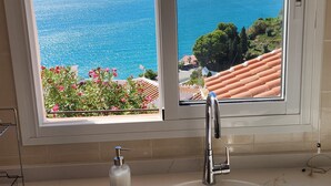 A kitchen with a sink and a window overlooking the sea. - Spacious and bright penthouse with panorama seaview (Nerja)