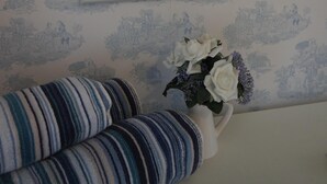 Une chambre à coucher avec un lit, une table de chevet, une lampe et un miroir.