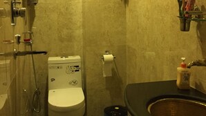 Un baño con inodoro, ducha y lavabo.