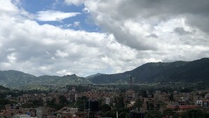 Un paisaje urbano con vistas a montañas y un cielo parcialmente nublado.