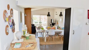 A cozy kitchen with a dining area, featuring a wooden table, chairs, and a view of the outside.