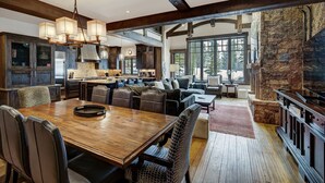 A spacious kitchen with dark wooden cabinets, a large island, and a stone accent wall.