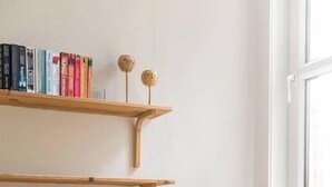 A room with a blue chair, a radiator, and bookshelves with decorative items. - Lovely central Edinburgh apartment (Edinburgh)