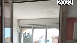 Un balcón con mesa, sillas y vistas a edificios.