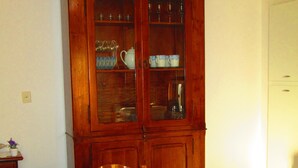 A dining room with a wooden table, chairs, and a cabinet with glass doors. - Apartment "La casa dei nonni" (Acqualagna)