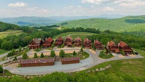 A lodge with multiple cabins, a central building, and a scenic mountain backdrop. - Peregrine's Perch- amazing views, hot tub, outdoor fireplace, Eagles Nest amenities (Banner Elk)