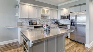 Una cocina moderna con armarios blancos, electrodomésticos de acero inoxidable y una isla grande.