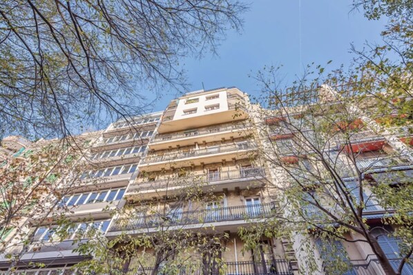 A multi-story building with balconies and a clear sky. - Sweett | Rocafort 401 (Barcelona)