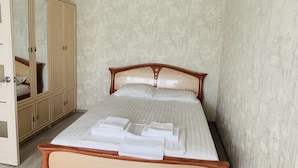 A bedroom with a wooden bed, a wardrobe, and a mirror. - Center. 1. 2 km to Deribasovskaya (Odesa)