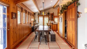 A wooden interior with a dining table, chairs, and a bench. - Mountaineer Manor- views, hot tub, 3 acres fenced in yard, pool table (Sugar Grove)