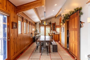 A wooden interior with a dining table, chairs, and a bench.